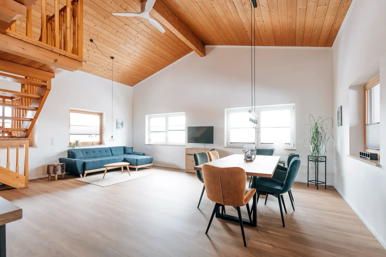 Wohn- und Essbereich der Ferienwohnung Kaiser Franz Josef auf dem Kaiser Camping Bad Feilnbach – offener Grundriss mit Holzgalerie, Esstisch und hellem Parkettboden
